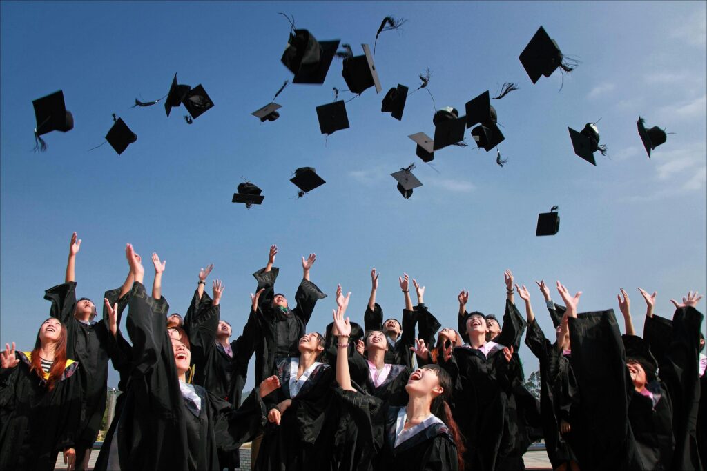 pexels-photo-267885-267885 Group of graduates celebrating by throwing caps in the air during a sunny day.